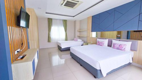 a hotel room with two beds and a television at APA-TREE Boutique Hotel in Natai Beach