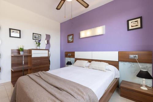 a bedroom with purple walls and a large bed at Apartamento Mare Internum I in La Pineda