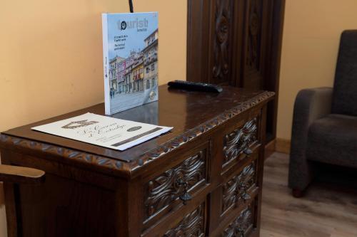 a wooden table with a sign on it next to a chair at La Casona De Entralgo in Pola de Laviana