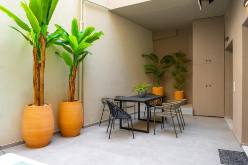 a dining room with a table and chairs and plants at Iaspis Luxury Suites in Bendevís