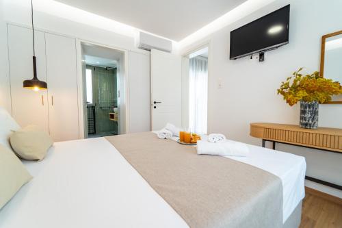 a hotel room with a bed and a tv on the wall at Iaspis Luxury Suites in Bendevís