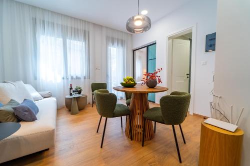 a living room with a table and chairs and a couch at Iaspis Luxury Suites in Bendevís