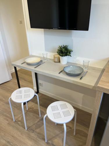 d'une table avec deux chaises et d'une télévision. dans l'établissement La parenthèse, confortable appartement 2 pièces, à Boisseuil