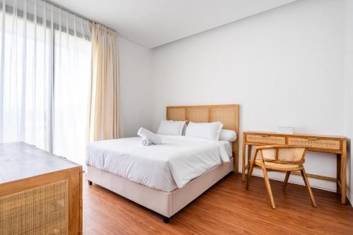 - une chambre avec un lit, un bureau et un lit dans l'établissement Vinca Villa Bali, à Kerobokan