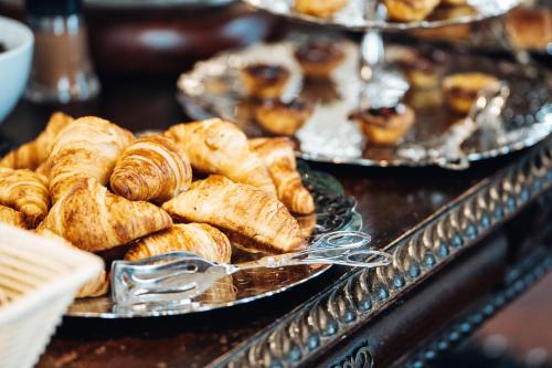 a bunch of pastries on plates on a table at GRANDE HOTEL PARIS by STAY HOTELS in Porto