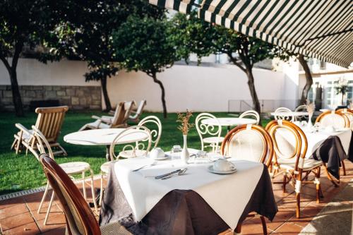 a group of tables and chairs under an umbrella at GRANDE HOTEL PARIS by STAY HOTELS in Porto
