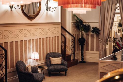 a living room with chairs and a table and a mirror at GRANDE HOTEL PARIS by STAY HOTELS in Porto