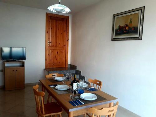 a dining room with a wooden table with chairs at Agriturismo Le Ville con Piscina idromassaggio, Capo Vaticano in Ricadi