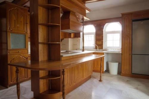 a kitchen with wooden cabinets and a large wooden island at Stone Villa Nea Potidaia in Nea Potidaea