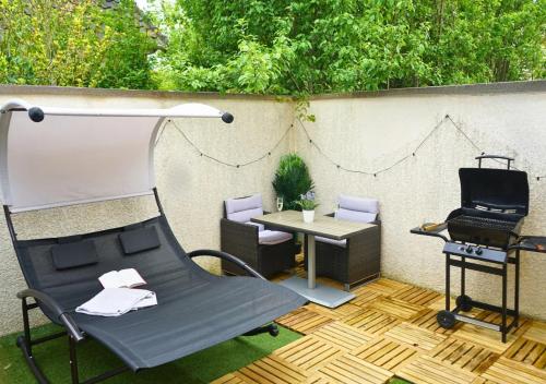 d'une terrasse avec une table, une chaise et un bureau. dans l'établissement Thermal & Home cinéma Disneyland Paris and Terrasse, à Lagny-sur-Marne