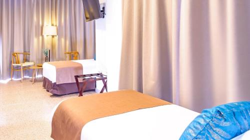 a hotel room with two beds and a window at Hotel Eden Mar in Guardamar del Segura