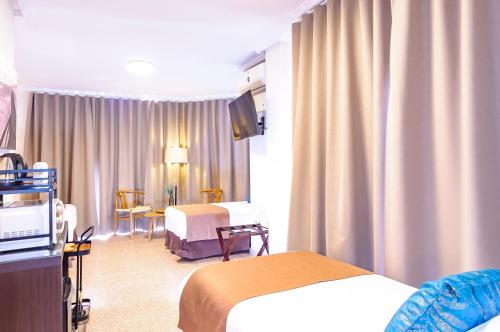 a hotel room with two beds and a television at Hotel Eden Mar in Guardamar del Segura