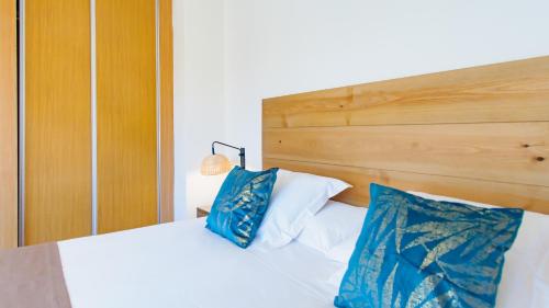 a bed with two blue pillows on top of it at Hotel Eden Mar in Guardamar del Segura