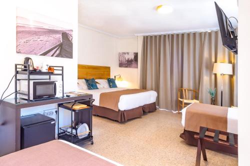 a hotel room with two beds and a television at Hotel Eden Mar in Guardamar del Segura