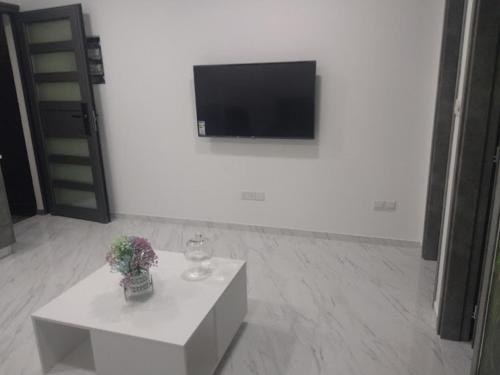 a white room with a television and a white table at Ermioni Apartments in Limassol