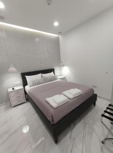a bedroom with a large bed with two towels on it at Ermioni Apartments in Limassol