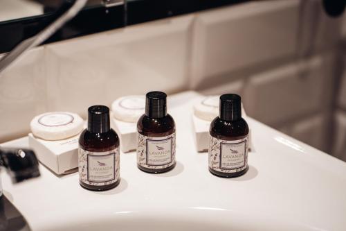 three bottles of medicine sitting on top of a sink at GRANDE HOTEL PARIS by STAY HOTELS in Porto