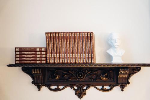 a group of books on a shelf with a bust at GRANDE HOTEL PARIS by STAY HOTELS in Porto
