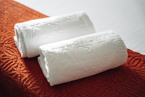 two white remote controls sitting on top of a bed at GRANDE HOTEL PARIS by STAY HOTELS in Porto