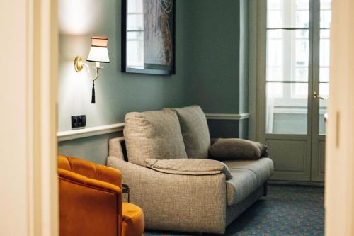 a living room with a couch and a chair at GRANDE HOTEL PARIS by STAY HOTELS in Porto