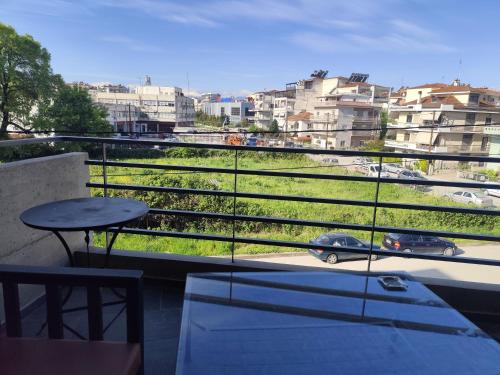 a balcony with a table and a view of a city at Celin's Appartment in Tríkala