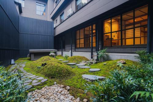 a garden in front of a building with a bench at Shinzan Kinosaki in Toyooka