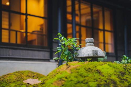 a fire hydrant in front of a building with a plant at Shinzan Kinosaki in Toyooka