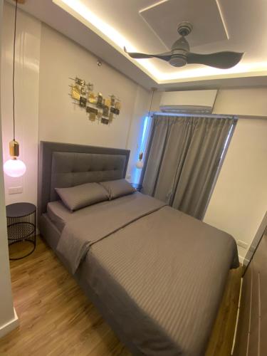 una camera da letto con un letto e un ventilatore a soffitto di Stylish & Spacious Place Near BGC Fast Wi-Fi a Manila