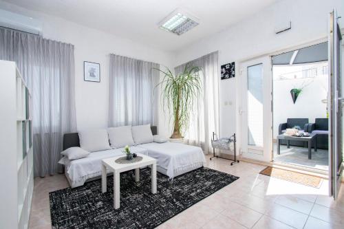 a white living room with a couch and a table at Family friendly house with a swimming pool Brodarica, Sibenik - 24117 in Šibenik
