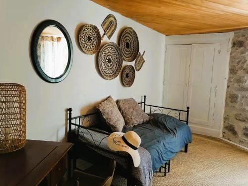 - un salon avec un lit, un miroir et un canapé dans l'établissement Maison au coeur du village de la Salvetat sur Agout, à La Salvetat-sur-Agout