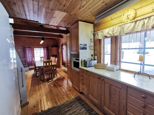 a kitchen with wooden cabinets and a large clock on the wall at Pikkulammenkuja 1A in Syöte