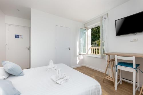 Cette chambre blanche dispose d'un lit, d'un bureau et d'une fenêtre. dans l'établissement Chambre indépendante Etoile, à Brest