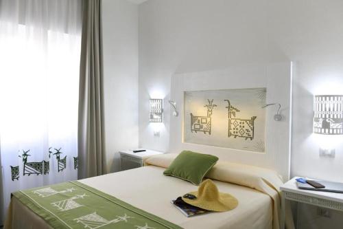 a bedroom with a bed with a hat on it at Alghero Sunrise in Alghero