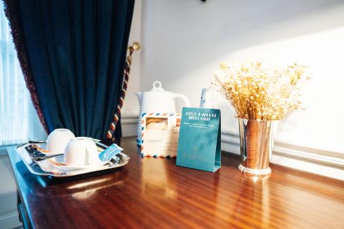 a table with a book and a vase of flowers at GRANDE HOTEL PARIS by STAY HOTELS in Porto