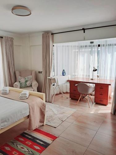a bedroom with a bed and a desk and a couch at POPSY HOMES NAKURU CBD in Nakuru