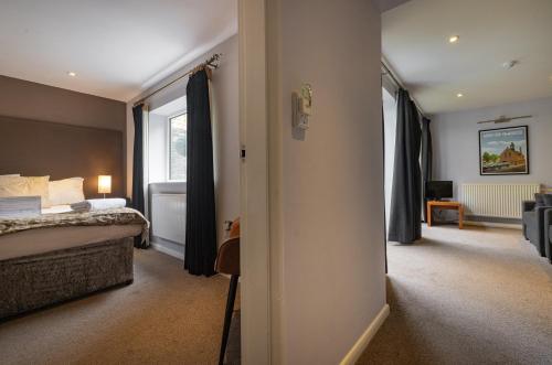 a hotel room with a bed and a window at Redesdale Arms Hotel in Moreton in Marsh