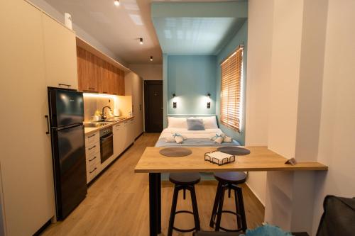 a small kitchen with a bed and a table in a room at Ocean-Πολυτελές διαμέρισμα στο Αγρίνιο in Agrinion