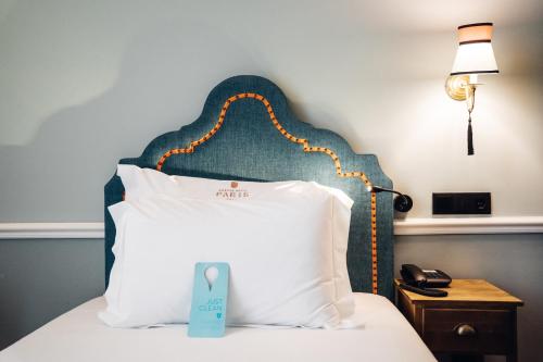 a hotel room with a bed with a pillow with a sign on it at GRANDE HOTEL PARIS by STAY HOTELS in Porto
