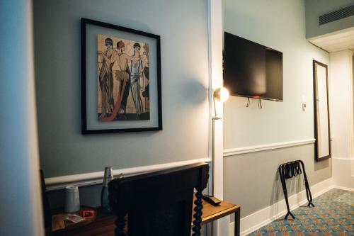 a hallway with a painting on the wall and a television at GRANDE HOTEL PARIS by STAY HOTELS in Porto