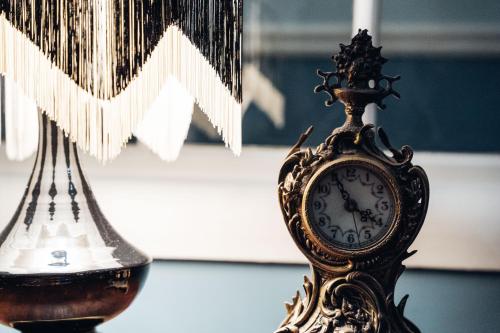 an ornate clock sitting next to a lamp at GRANDE HOTEL PARIS by STAY HOTELS in Porto