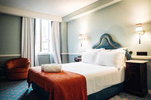 a hotel room with a bed and a chair at GRANDE HOTEL PARIS by STAY HOTELS in Porto