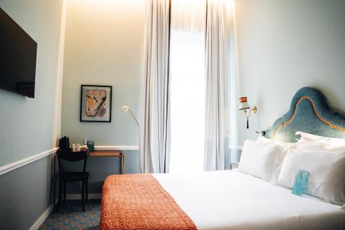 a bedroom with a bed and a desk in a room at GRANDE HOTEL PARIS by STAY HOTELS in Porto