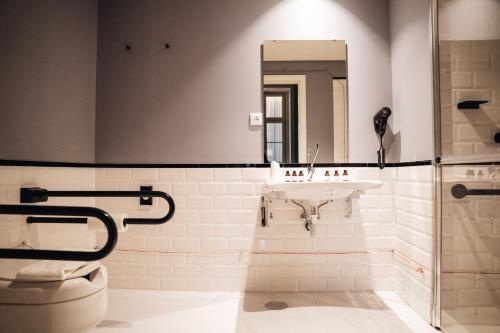 a bathroom with a sink and a toilet and a mirror at GRANDE HOTEL PARIS by STAY HOTELS in Porto