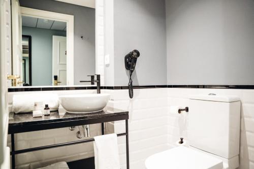 a bathroom with a sink and a toilet and a mirror at GRANDE HOTEL PARIS by STAY HOTELS in Porto