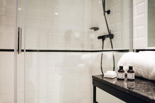 a bathroom with a shower and two bottles on a counter at GRANDE HOTEL PARIS by STAY HOTELS in Porto