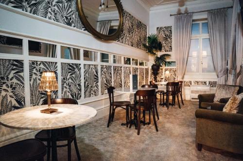 a living room with tables and chairs and a mirror at GRANDE HOTEL PARIS by STAY HOTELS in Porto