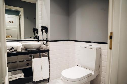 a bathroom with a white toilet and a sink at GRANDE HOTEL PARIS by STAY HOTELS in Porto