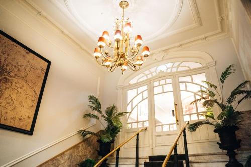 a chandelier in a hallway with a staircase at GRANDE HOTEL PARIS by STAY HOTELS in Porto