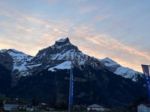 a snow covered mountain in front of a city at Ski Hide Out Engelberg, Titlis, Luzern in Engelberg