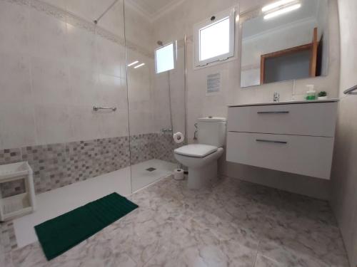 ein Badezimmer mit Toilette und Glasdusche in der Unterkunft MarySol 2 Apartment with terrace close to the sea in Punta de Mujeres